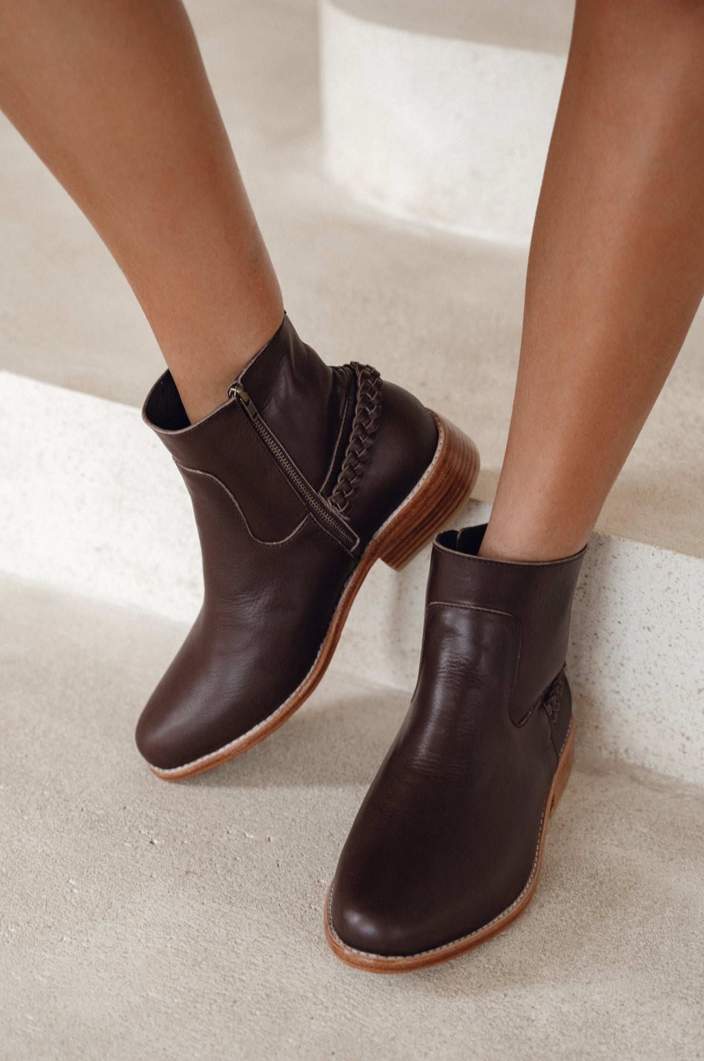Brown leather ankle boots on a neutral background