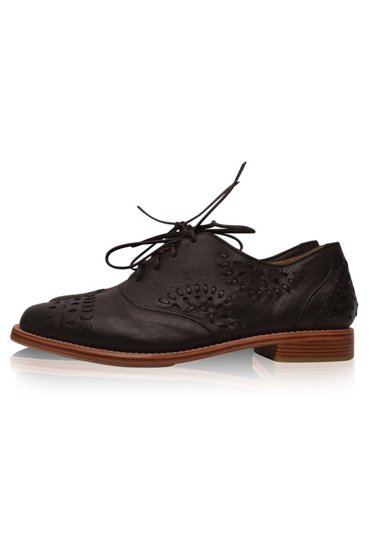 Black leather brogue shoe with brown sole on a white background
