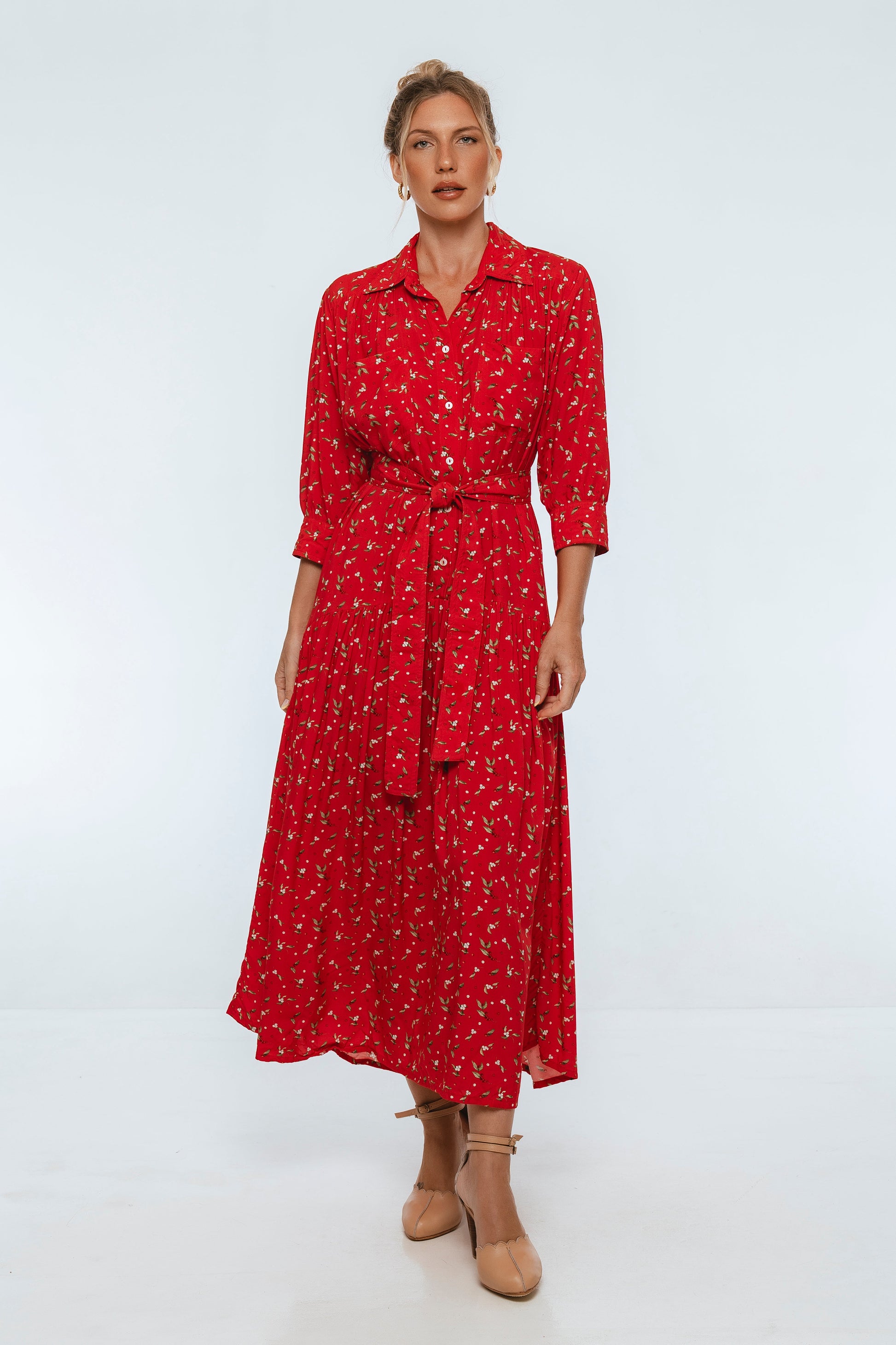 Woman wearing a red patterned dress on a white background