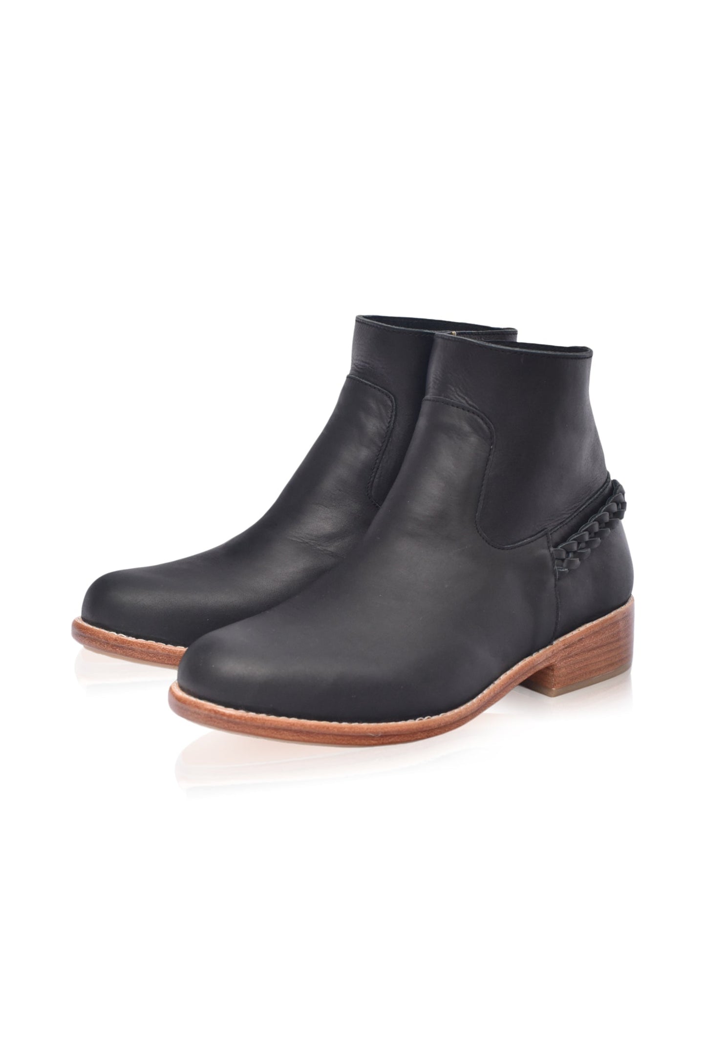 Black ankle boots with brown soles on a white background
