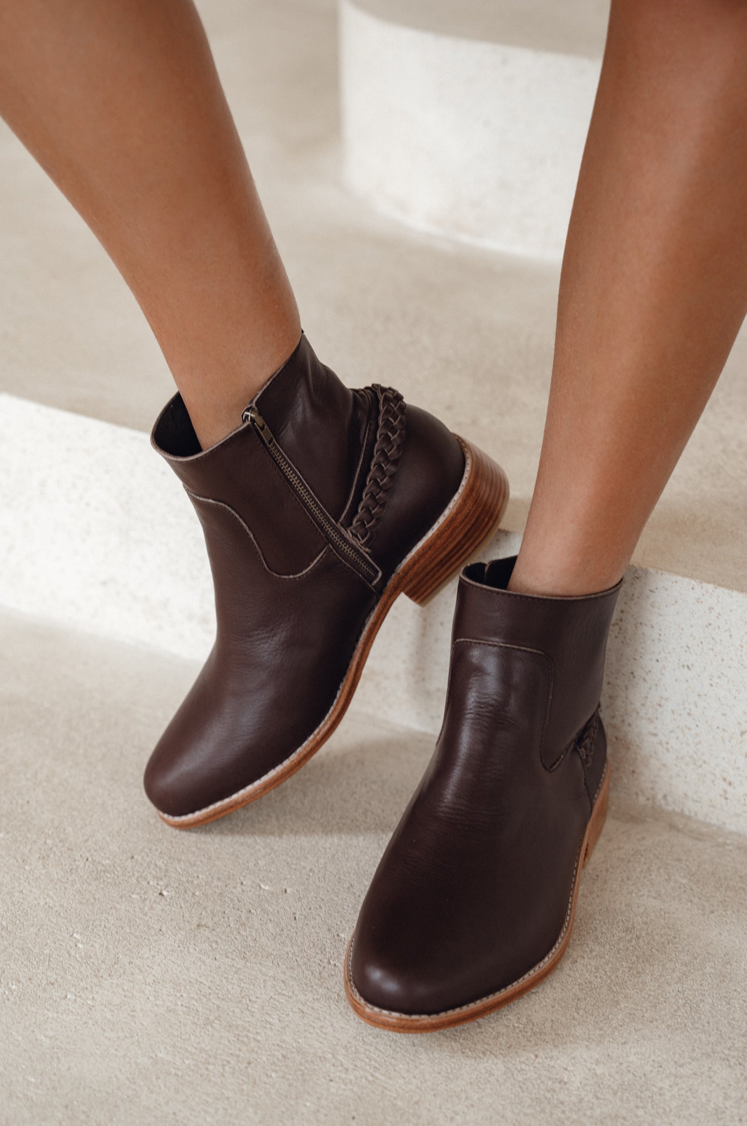 Brown leather ankle boots on a neutral background