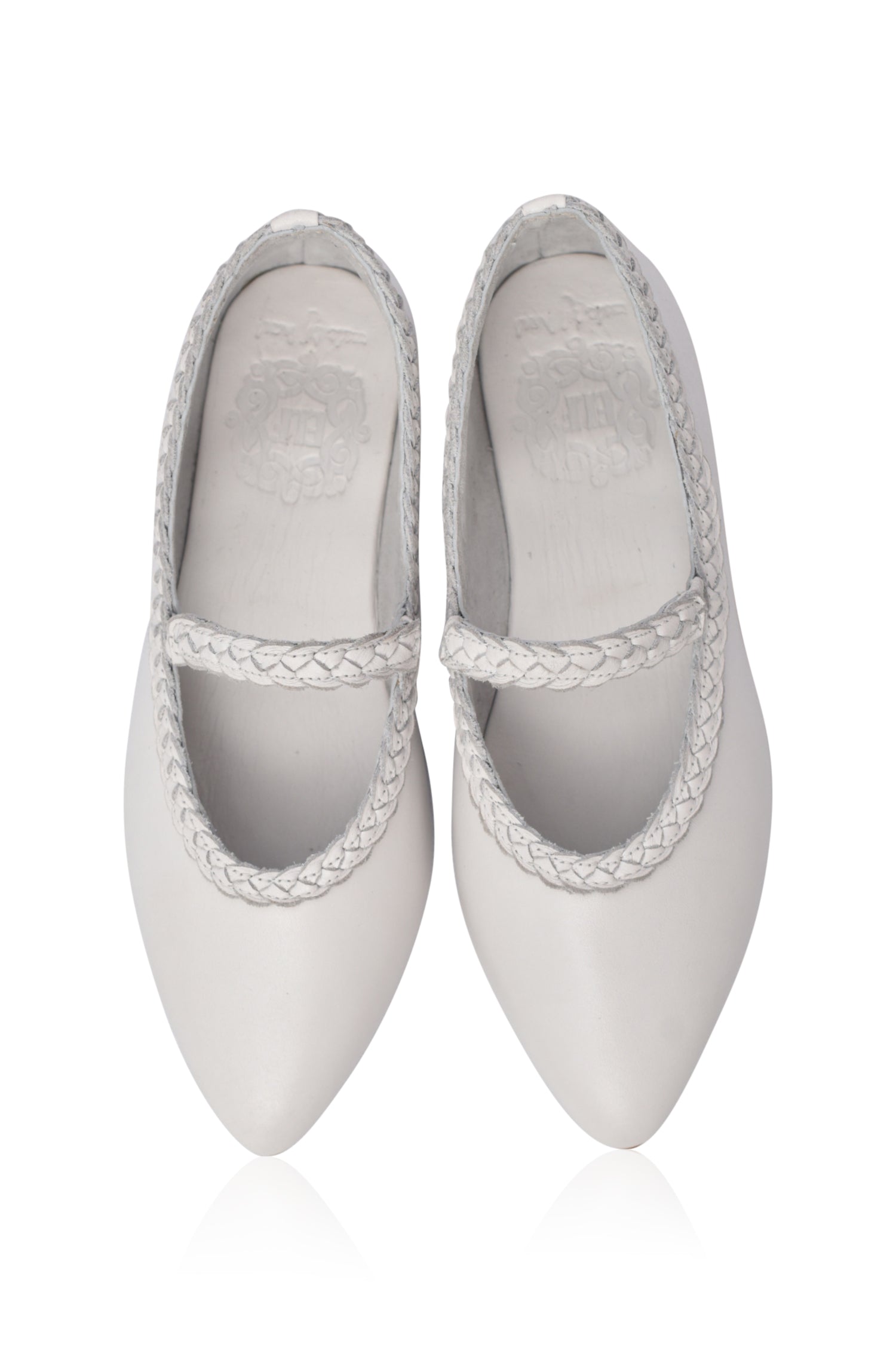 Pair of white pointed-toe shoes with braided straps on a white background