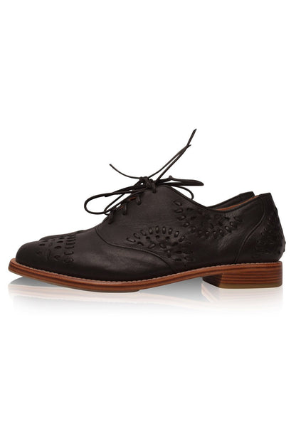 Black leather brogue shoe with brown sole on a white background
