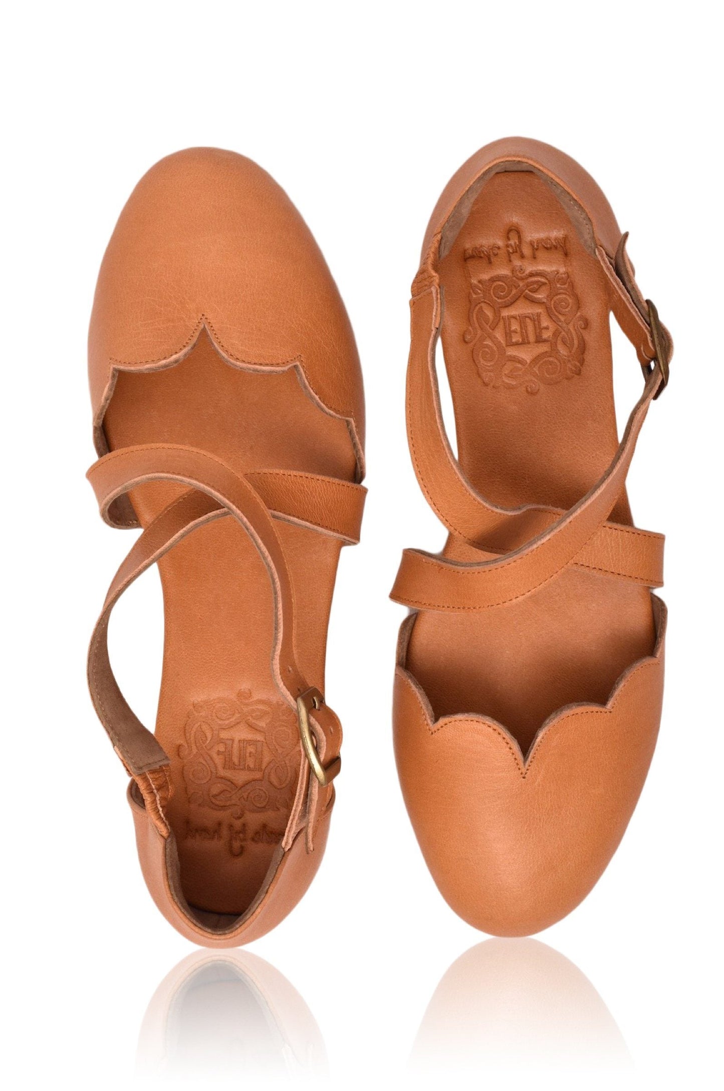 Pair of tan leather sandals with cut-out design on a white background
