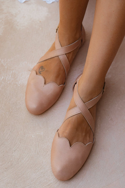 Pair of beige ballet flats on a light background