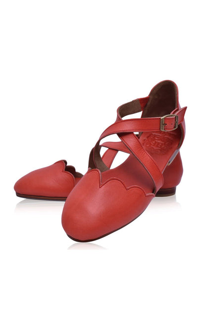 Red leather shoes with a strap on a white background