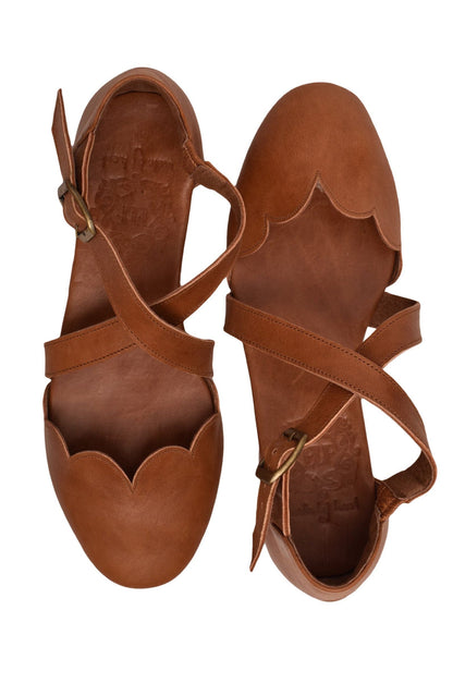 Pair of brown leather sandals with strap details on a white background