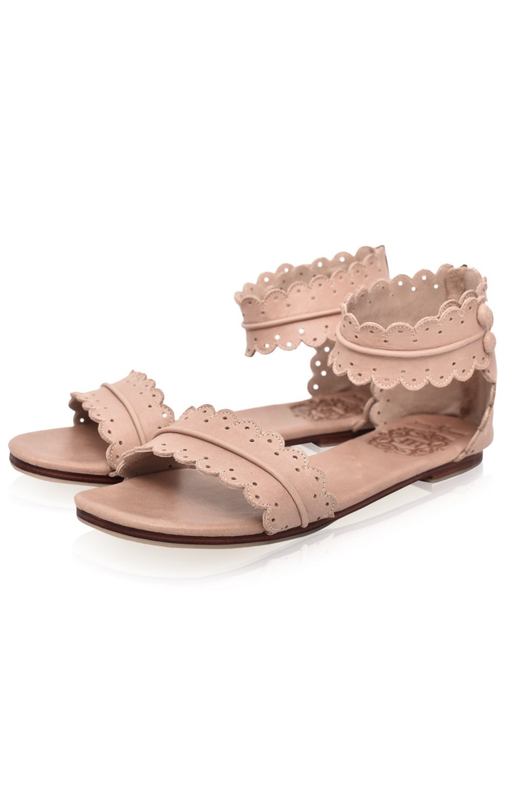 Pair of pink sandals with lace detailing on a white background