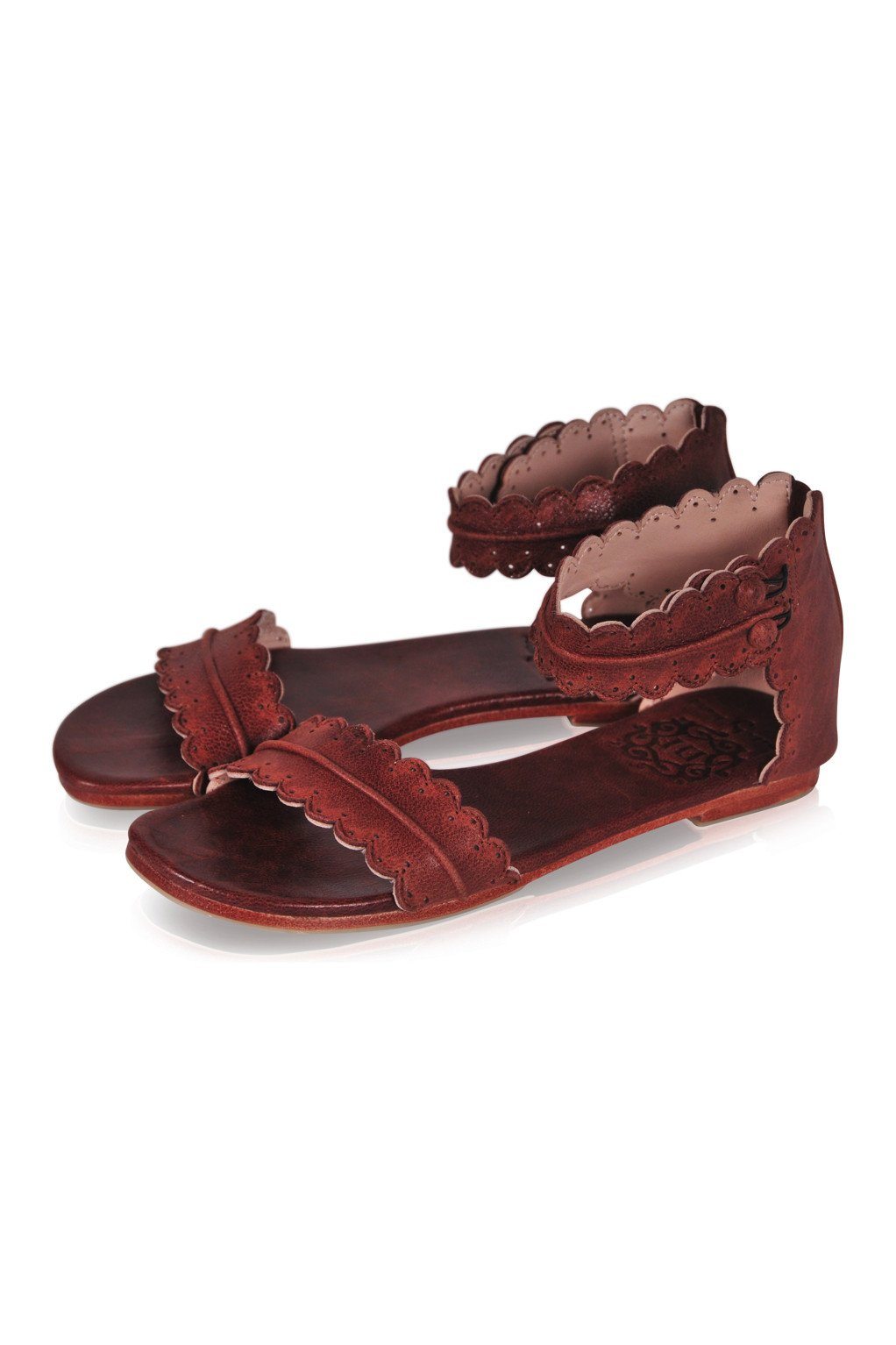 Pair of brown sandals with decorative straps on a white background