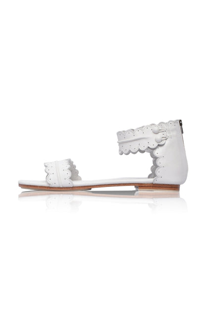 White sandal with lace details on a white background