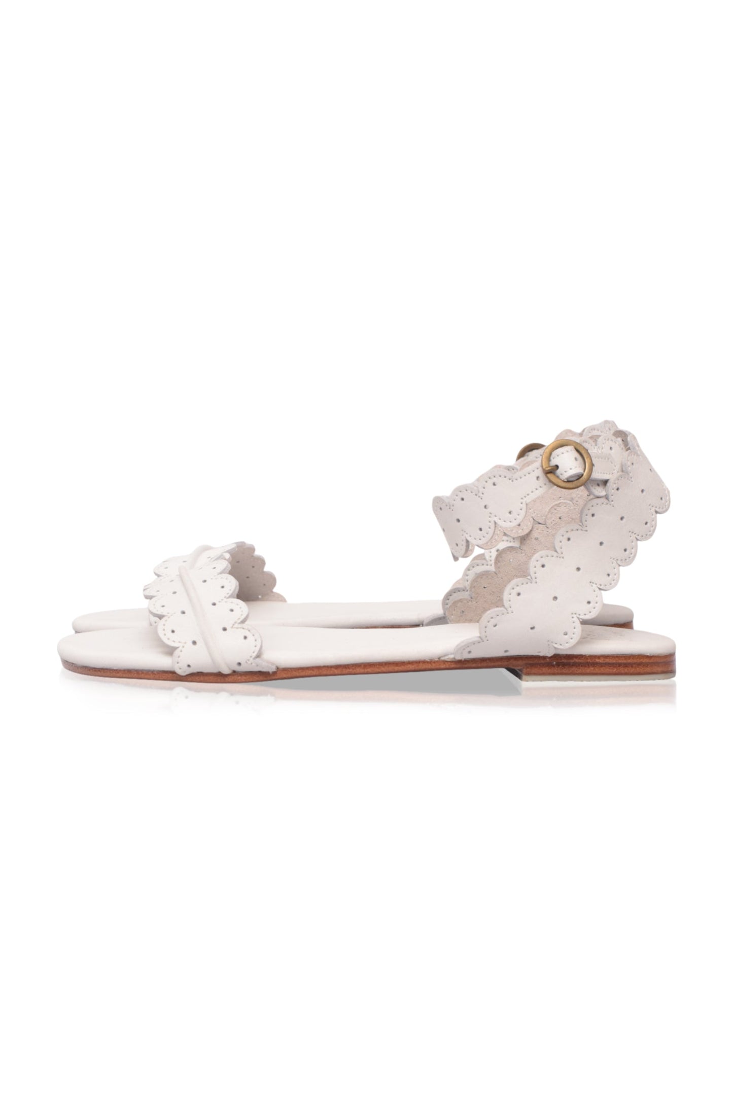 White sandal with ruffled details on a white background
