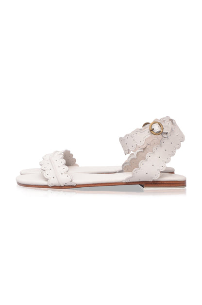White sandal with ruffled details on a white background