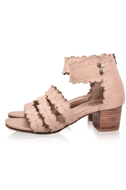 Pair of beige lace-up shoes with a wooden block heel on a white background