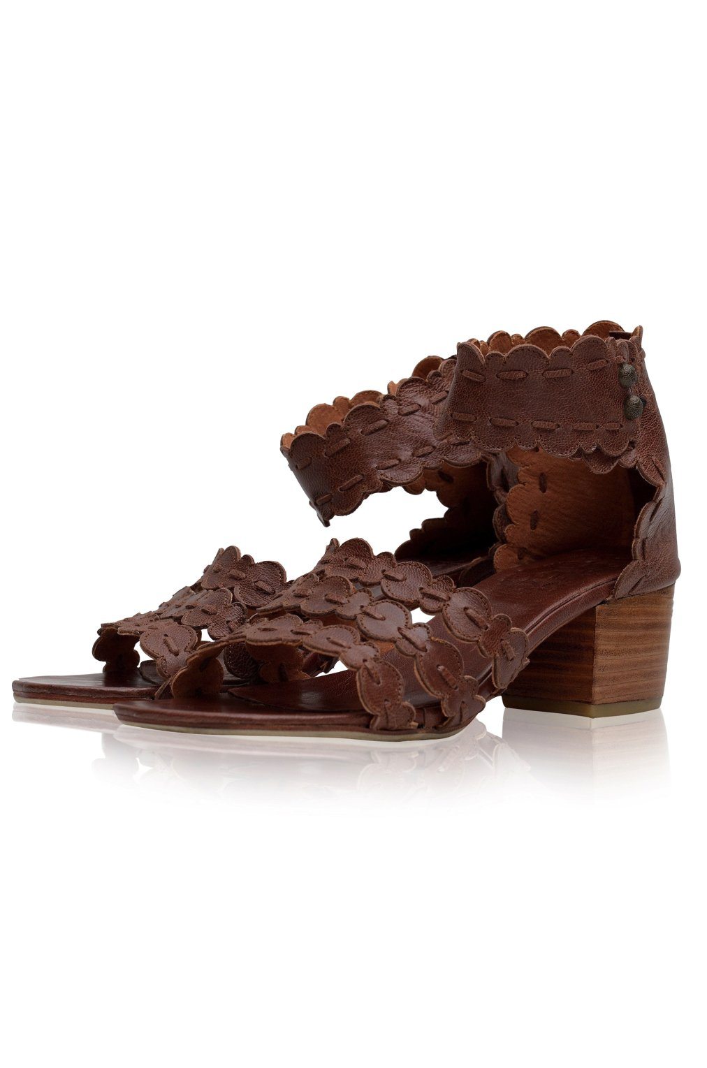 Brown sandal with intricate cut-out design on a white background