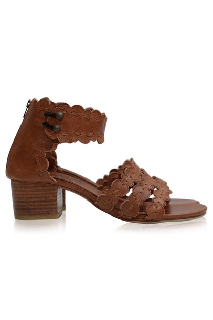Brown sandal with floral lace design on a white background