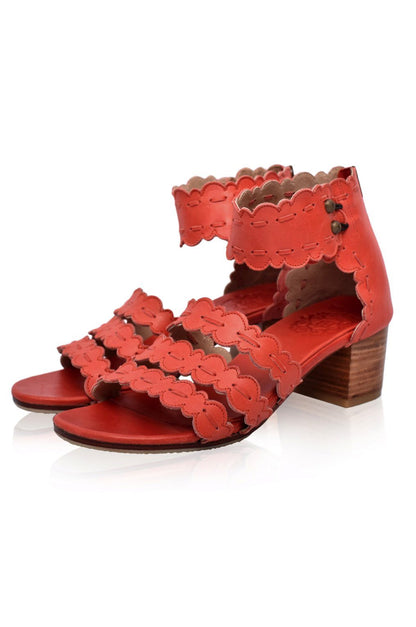 Red sandal with scalloped edges on a white background